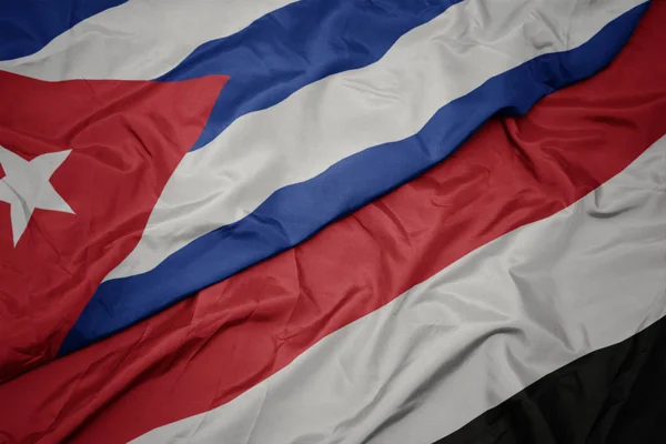 Jemen és a kubai nemzeti zászló hullámzó színpompás zászlaja. — Stock Fotó