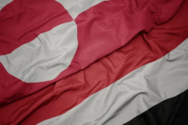 Ondeando colorida bandera de yemen y bandera nacional de Groenlandia . — Foto de Stock