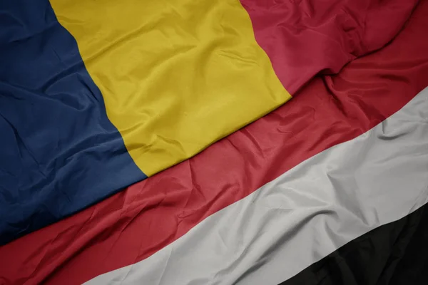 Acenando bandeira colorida do Iêmen e bandeira nacional do chad . — Fotografia de Stock