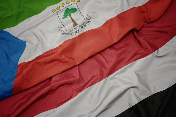 Sventolando bandiera colorata di yemen e bandiera nazionale di ghinea equatoriale . — Foto Stock