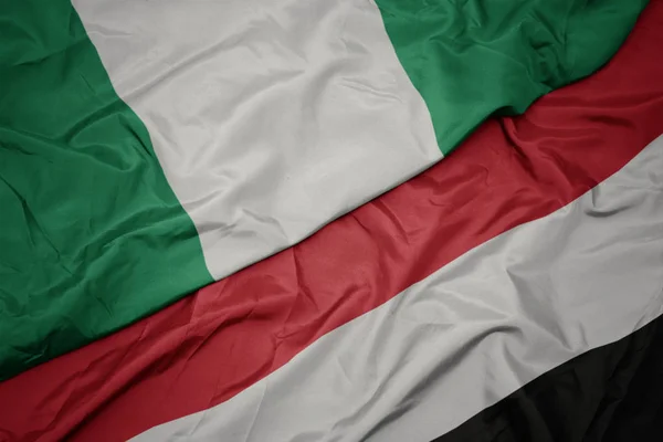 Waving colorful flag of yemen and national flag of nigeria. — Stock Photo, Image