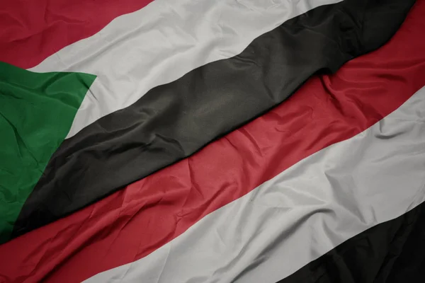 Waving colorful flag of yemen and national flag of sudan. — Stock Photo, Image