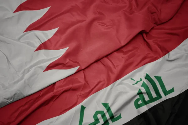 Sventolando bandiera colorata dell'Iraq e bandiera nazionale di Bahrain . — Foto Stock