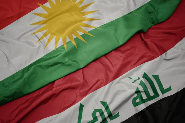 Ondeando colorida bandera de iraq y bandera nacional de kurdistan . — Foto de Stock