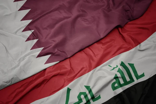 Sventolando bandiera colorata dell'Iraq e bandiera nazionale del Qatar . — Foto Stock