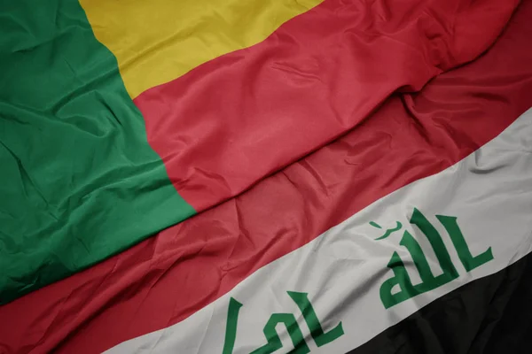 Sventolando bandiera colorata dell'Iraq e bandiera nazionale del Benin . — Foto Stock