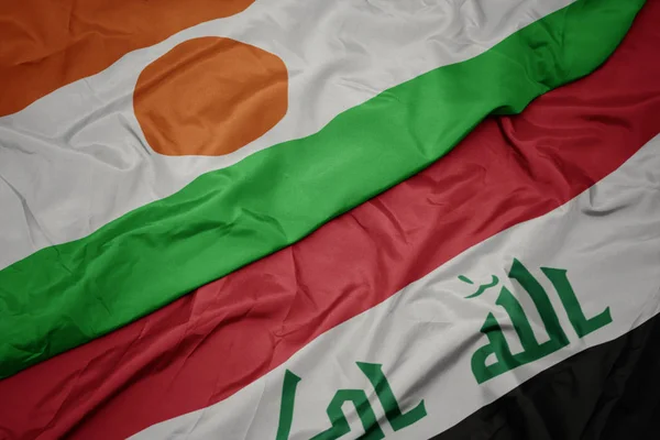 Sventolando bandiera colorata dell'Iraq e bandiera nazionale del Niger . — Foto Stock