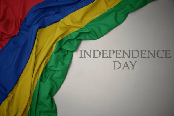 Ondeando colorida bandera nacional de Mauritius sobre un fondo gris con el día de la independencia del texto . — Foto de Stock