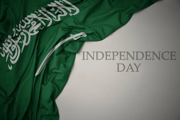 Waving colorful national flag of saudi arabia on a gray background with text independence day. — Stock Photo, Image