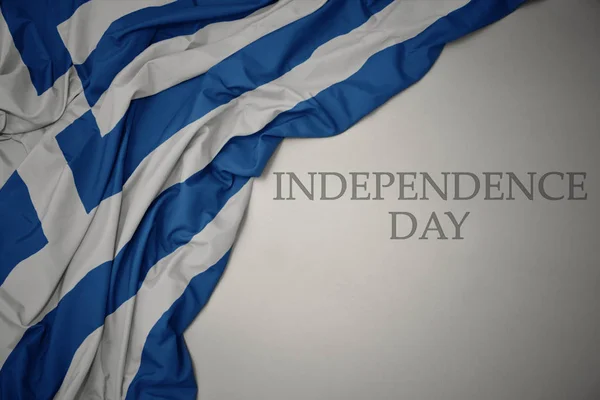 Hullámzó színes nemzeti zászló Görögország egy szürke háttér szöveges függetlenség napja. — Stock Fotó