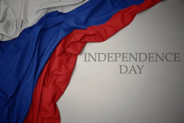 Schwenkt bunte russische Nationalflagge auf grauem Hintergrund mit Text zum Unabhängigkeitstag. — Stockfoto
