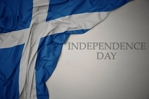 Ondeando colorida bandera nacional de Escocia sobre un fondo gris con el día de la independencia de texto . —  Fotos de Stock