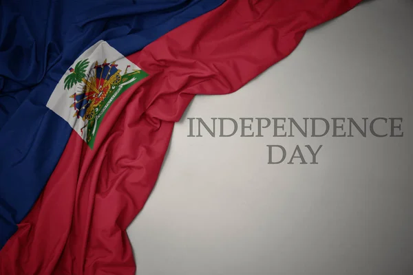 Acenando bandeira nacional colorida do haiti em um fundo cinza com o dia da independência do texto . — Fotografia de Stock