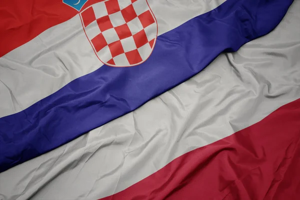 Mávající barevná vlajka Polska a národní vlajky Chorvatska. — Stock fotografie
