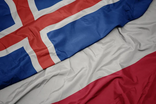 Zwaaiende kleurrijke vlag van Polen en de nationale vlag van IJsland. — Stockfoto