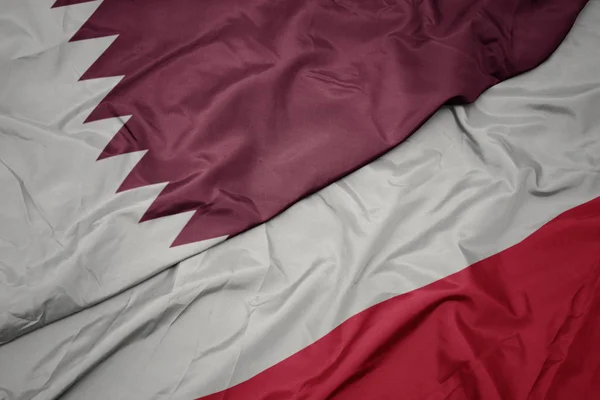 Schwenken bunte Flagge von Polen und Nationalflagge von Katar. — Stockfoto
