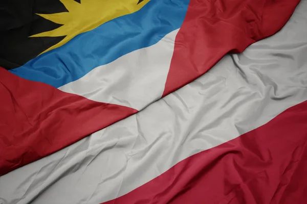 Acenando bandeira colorida de polônia e bandeira nacional de antigua e barbuda . — Fotografia de Stock