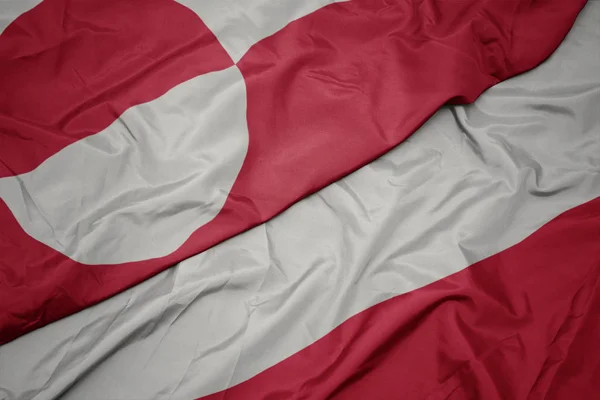 Ondeando colorida bandera de Polonia y bandera nacional de Groenlandia . — Foto de Stock