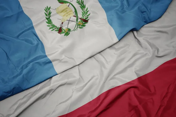 Mávající barevná vlajka Polska a národní vlajky Guatemaly. — Stock fotografie