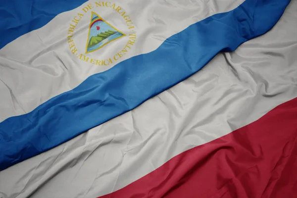 Schwenken bunte Flagge von Polen und Nationalflagge von Nicaragua. — Stockfoto