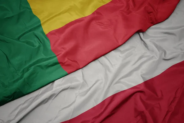 Waving colorful flag of poland and national flag of benin. — Stock Photo, Image