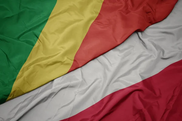 Machanie kolorową flagą Polski i narodową flagą Republiki Konga. — Zdjęcie stockowe