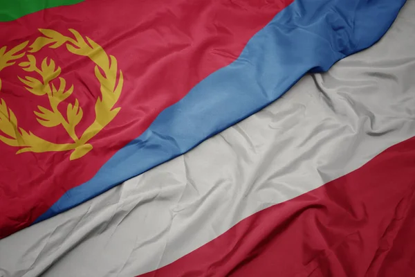 Falująca kolorowa flaga Polski i flaga narodowa Erytrei. — Zdjęcie stockowe