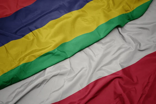 Ondeando colorida bandera de Polonia y bandera nacional de Mauricio . — Foto de Stock