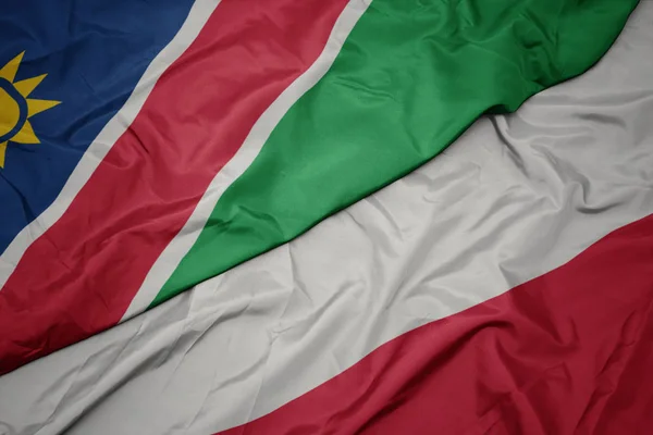 Machanie kolorową flagą Polski i flagą narodową Namibii. — Zdjęcie stockowe