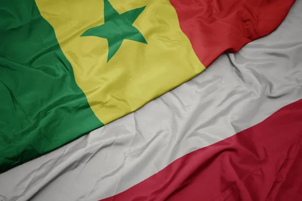 Schwenken bunte Flagge Polens und Nationalflagge Senegals. — Stockfoto