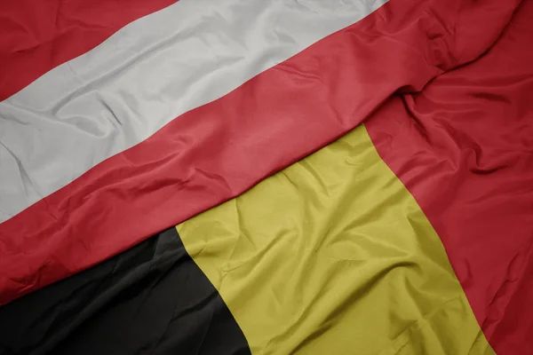 Machanie kolorową flagą Belgii i flagą narodową Australii. — Zdjęcie stockowe