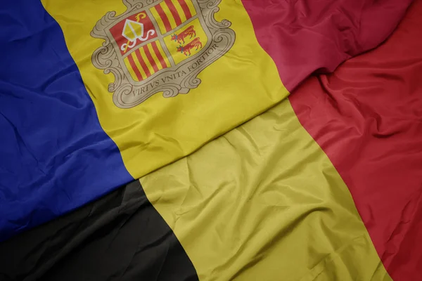 Sventolando bandiera colorata di belgio e bandiera nazionale di andorra . — Foto Stock