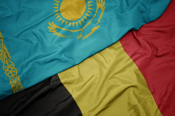 Belçika 'nın renkli bayrağı ve Kazakistan' ın ulusal bayrağı sallanıyor.. — Stok fotoğraf