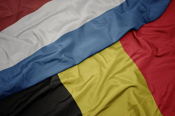 Sventolando bandiera colorata di belgio e bandiera nazionale di luxembourg . — Foto Stock