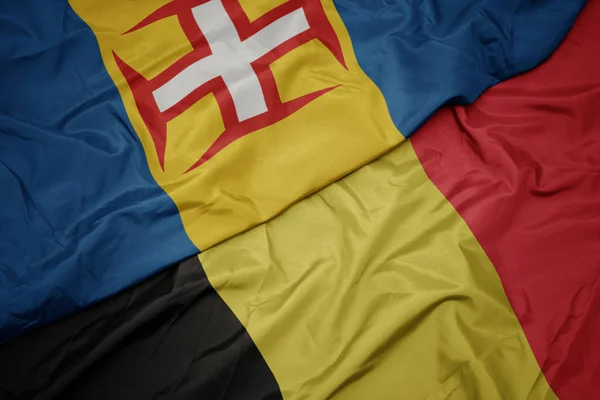 Ondeando colorida bandera de Bélgica y bandera nacional de Madeira . —  Fotos de Stock