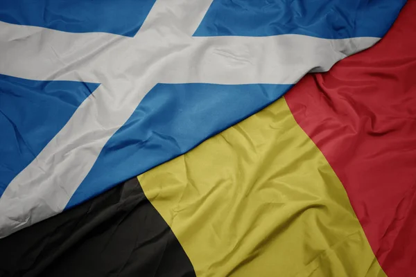 Zwaaiende vlag van België en nationale vlag van Schotland. — Stockfoto