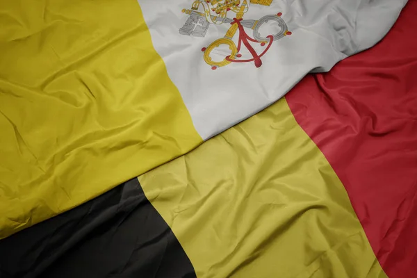 Viftande färgglada flagga belgium och nationell flagga vatican stad. — Stockfoto