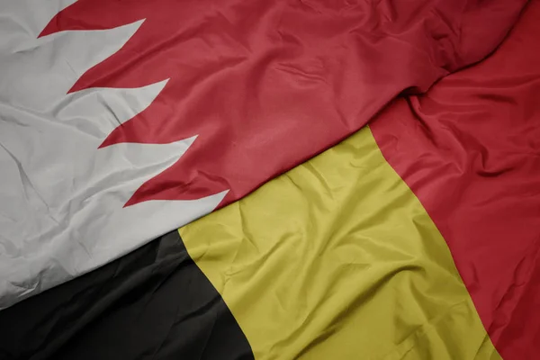 waving colorful flag of belgium and national flag of bahrain.