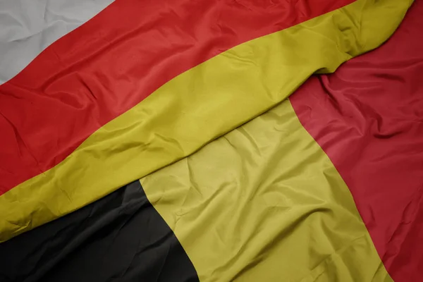 Acenando bandeira colorida de bélgica e bandeira nacional da ossétia do sul . — Fotografia de Stock
