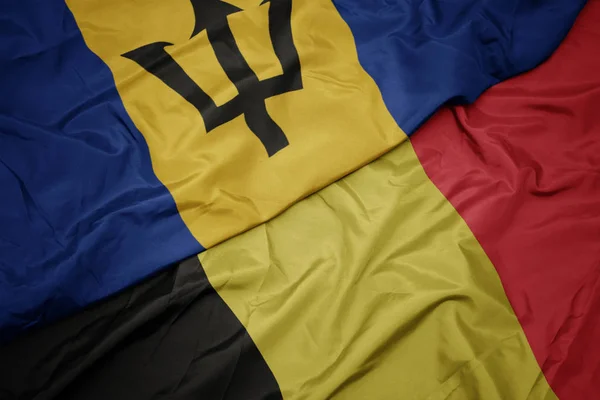 Ondeando colorida bandera de belgium y bandera nacional de barbados . —  Fotos de Stock