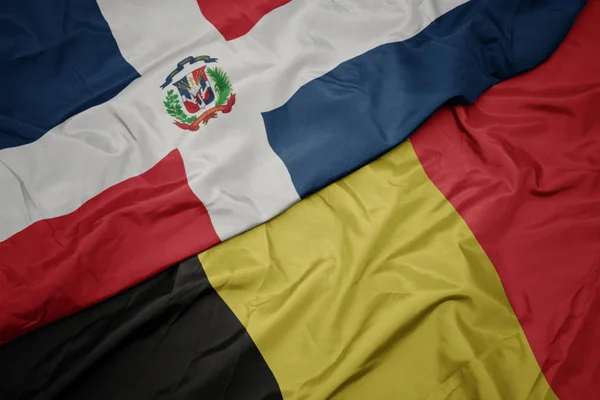 Ondeando colorida bandera de Bélgica y bandera nacional de República Dominicana . — Foto de Stock