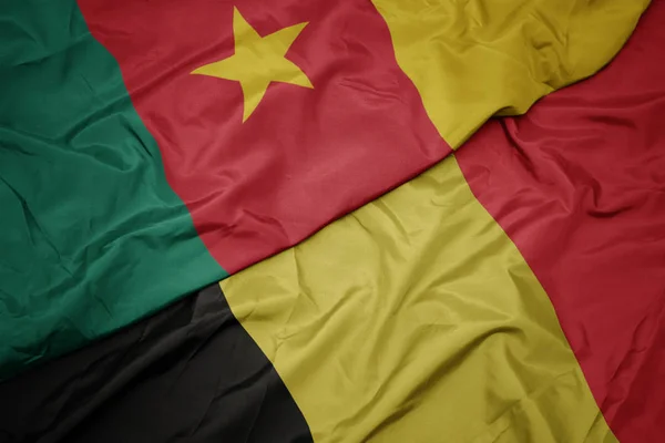 Ondeando colorida bandera de Bélgica y bandera nacional de Camerún . —  Fotos de Stock