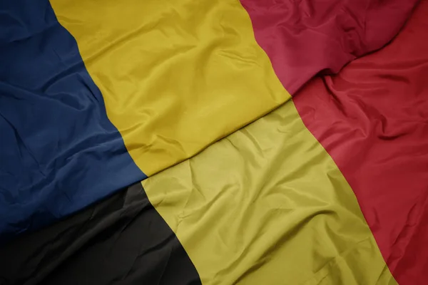 Acenando bandeira colorida de bélgica e bandeira nacional de chad . — Fotografia de Stock