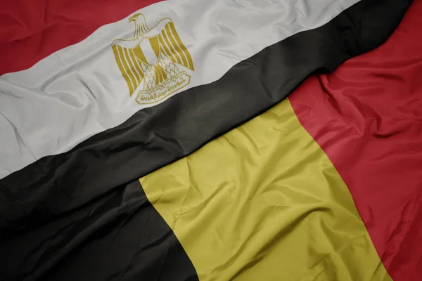 Ondeando colorida bandera de Bélgica y bandera nacional de Egipto  . — Foto de Stock