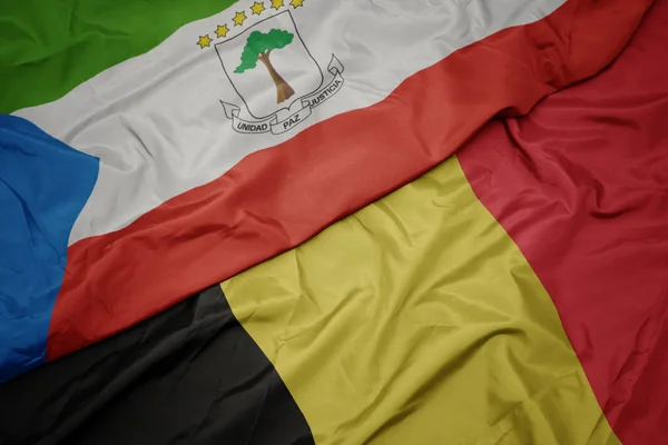 Ondeando colorida bandera de Bélgica y bandera nacional de Guinea Ecuatorial . —  Fotos de Stock
