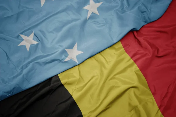 Sventolando bandiera colorata di belgio e bandiera nazionale degli Stati Federati di Micronesia  . — Foto Stock
