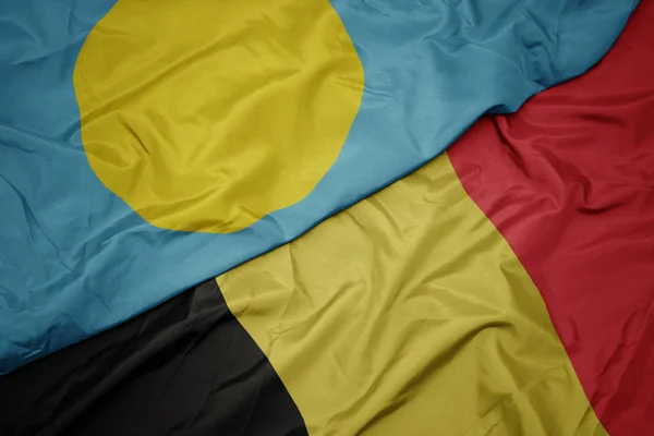 Wapperende vlag van België en nationale vlag van Palau . — Stockfoto
