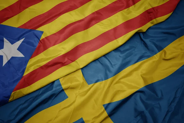 Ondeando colorida bandera de Suecia y bandera nacional de catalonia . —  Fotos de Stock