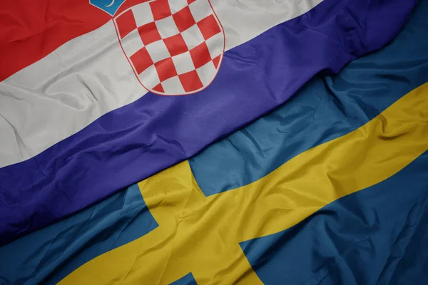 Machanie kolorową flagą Szwecji i flagą narodową Chorwacji. — Zdjęcie stockowe