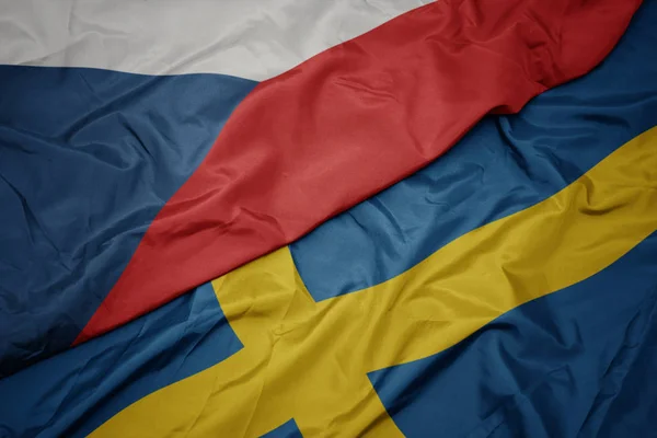 Machanie barwną flagą Szwecji i flagą narodową Republiki Czeskiej. — Zdjęcie stockowe